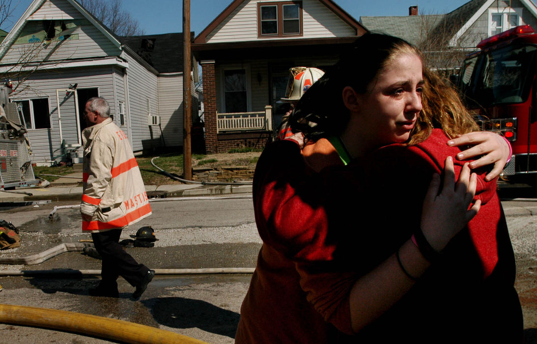 Third Place, Student Photographer of the Year Award - Michael P. King / Ohio UniversityLanie Lupfer, 13, facing, hugs her cousin Clara Timson, 13, while waiting to have the family dog, Harley, safely returned after a fire damaged her grandmother’s home at 1025 2nd Ave. in Evansville, Ind., March 28, 2005. The dog was chained behind the residence until long after the fire was extinguished.