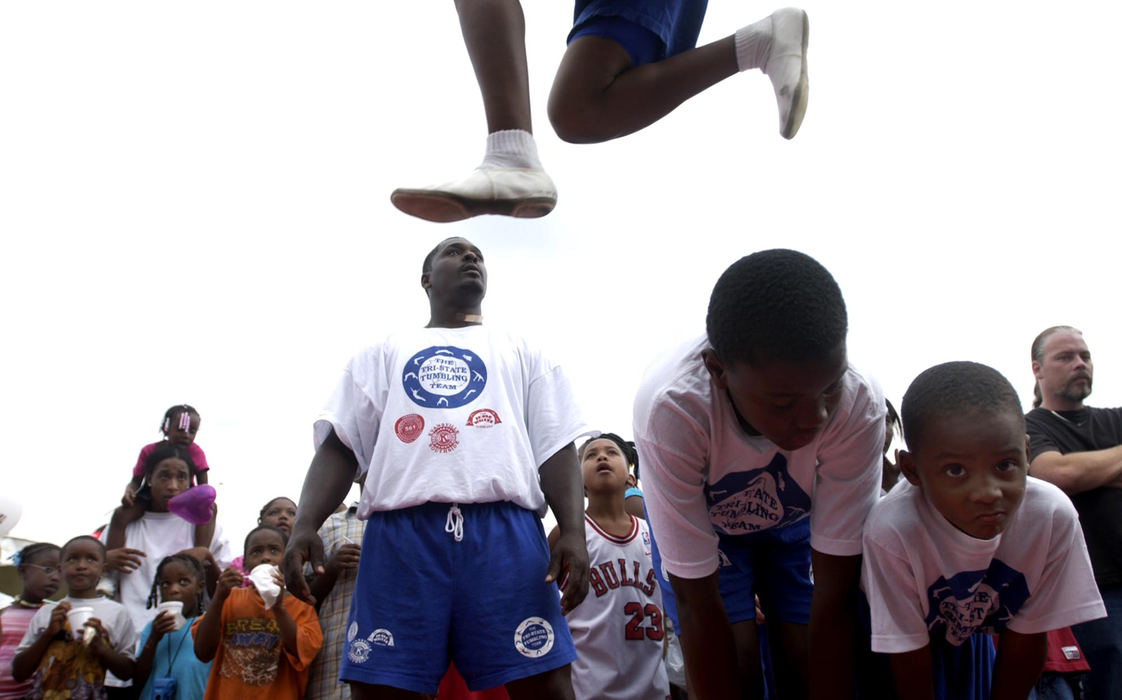 Award of Excellence, Student Photographer of the Year Award - Sung H. Jun  / Ohio UniversityThe Tri-State Tumbling Team member Tydell Jr. McNeal, (top, 15), jumps over Ivan Woods, 12, and Kristofer Mingo, right, as team founder and Tydell’s father, Tydell McNeal, (center) watches during the 7th Annual Family Day at Bellemeade Park in Evansville.