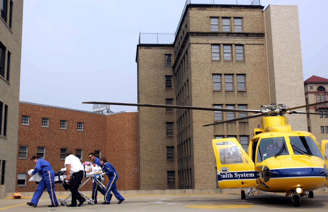 Award of Excellence, Student Photographer of the Year Award - Sung H. Jun  / Ohio UniversityEven before pilot-in-command Joseph Fawsitt cuts the helicopter's engine, Lorenz, far left, and Clewell, far right, begin to unload the trauma patient with the help of second-in-command pilot Thomas Bencin, second from left, and flight nurse specialist Jason Welch, next to Clewell. Life Flight stabilizes trauma patients before they are transported.