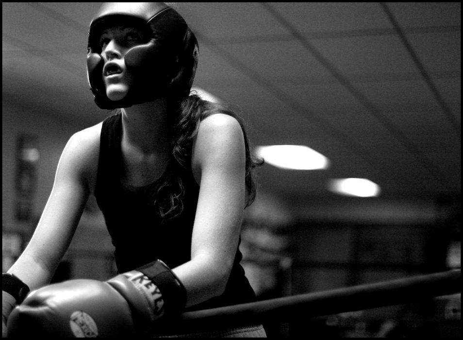 Second Place, Sports Picture Story - Katie Falkenberg / Ohio UniversityJessica McCoy is training to become a pro boxer. After discovering boxing and Sam’s Gym when she came to Athens as a student at Ohio University five years ago, the sport has become her life. During her training nights, she is most often the only female in the gym, leaving her no choice but to spar with the men.  Jessica rests on the ropes after sparring with a man in Sam’s Gym. Two times a week, she makes the commute from London, Ohio, to Glouster, where she trains by sparring, hitting the punching bag, and doing strength training.
