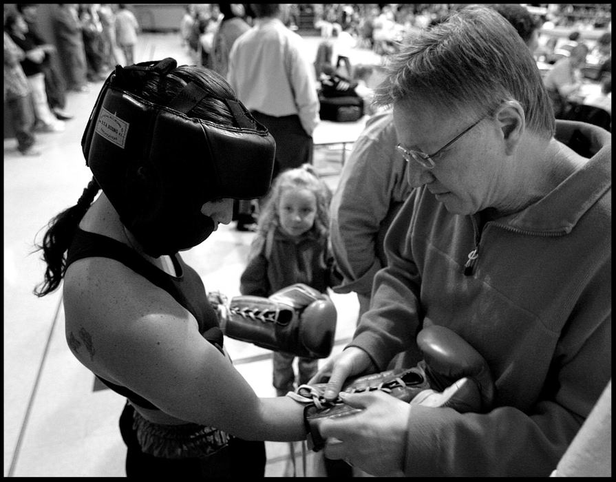 Second Place, Sports Picture Story - Katie Falkenberg / Ohio UniversityAs Jessica gets assistance with her gloves before taking the ring at Trimble Middle School, a young girl looks up admiringly.