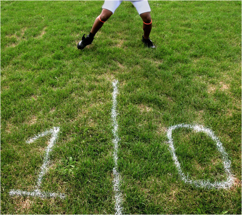 Award of Excellence, Sports Picture Story - Ed Suba, Jr. / Akron Beacon JournalAn Ohio Valley Bengal player stretches on a field that has been crudely lined and numbered with a paintbrush by the team's owner Misty Brown and several volunteers before the game at the University of Akron's former practice field in Akron. With almost no team budget to speak of, all work and providing of the game-day necessities (such as lining the field, setting up a concession stand and arranging for officials) are done by team members or volunteers. Players, who are not paid, are responsible for buying their own equipment and uniforms. 