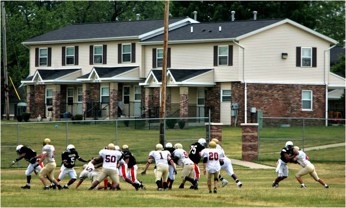 Award of Excellence, Sports Picture Story - Ed Suba, Jr. / Akron Beacon JournalThe Ohio Valley Bengals run a play against the Buffalo Warriors on their home field, which was nothing more than an uneven, rutted expanse of grass next to the Joy Park Housing Complex in Akron. The team used to play games on high school fields until the city stopped that after crowd problems at other semi-pro games caused trouble in the neighborhoods in past years. The Bengals, with some aid from the city of Akron, hope to build a facility at Joy Park that they can use for years to come. 
