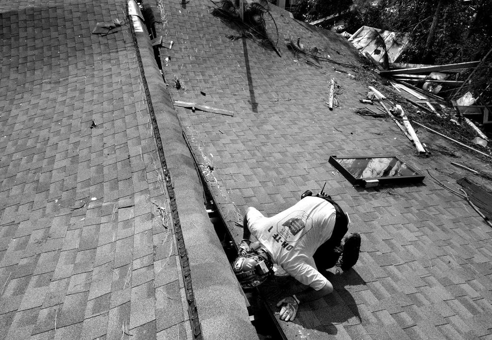 First place, Team Picture Story - JOSHUA GUNTER / The Plain DealerDoug Cope,  with the FEMA Ohio Task Force 1, calls out for survivors into an attic of a collapsed home in Pas Christian, Mississippi, September 03, 2005. 