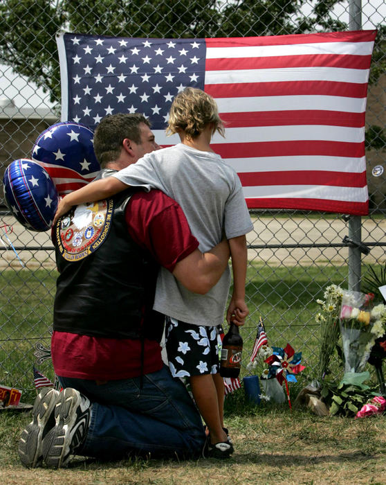 Second Place, Team Picture Story - DALE OMORI / The Plain DealerPersian Gulf War veteran Kelly Sherwood and his son, Brad Sherwood, 10, visit the makeshift memorial outside the Marine base in Brook Park on  Aug. 4, 2005.  