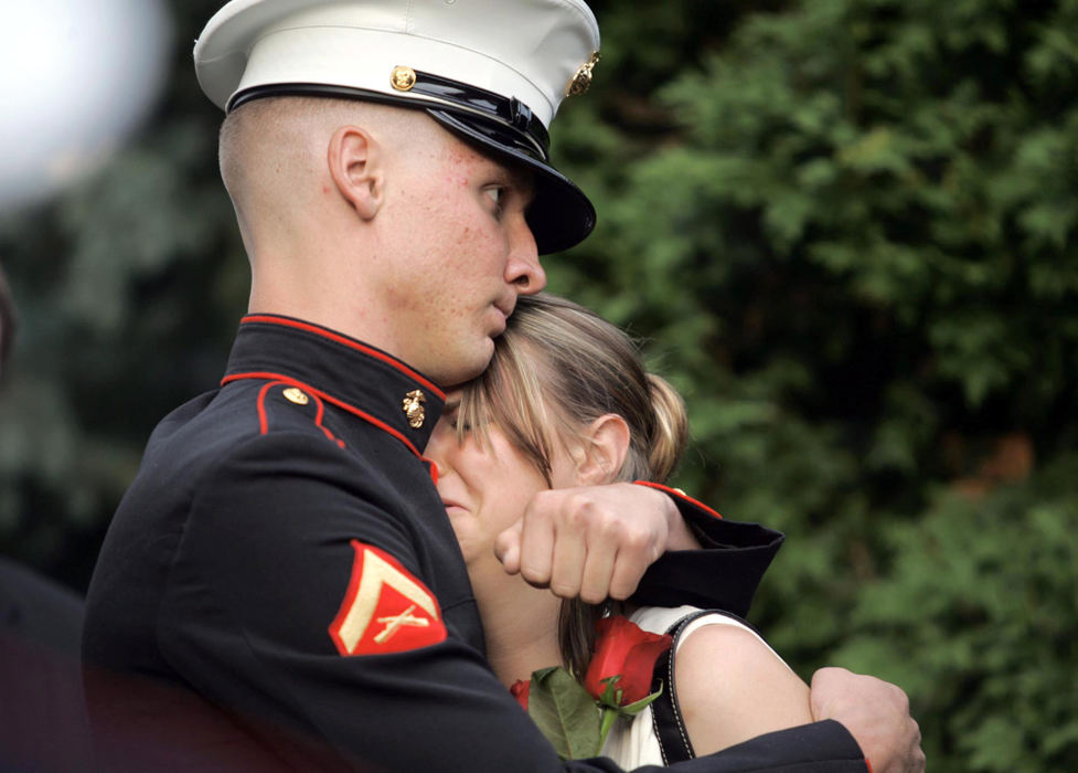 Second Place, Team Picture Story - EUSTACIO HUMPHREY / The Plain DealerU.S. Marine Eric Montgomery, brother of marine Lance Cpl. Brian Montgomery comforts Pam Montgomery, the wife of his older brother, Aug. 6, 2005, in Willougby. Eric Montgomery who is in the same unit, the Headquarters and Service Company 3rd Battalion, 25th Marines based in Brook Park, as his brother escorted his body home from Iraq on Saturday. Brian Montgomery was killed Aug. 3, 2005 in Iraq. 