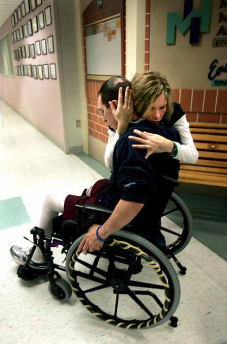 Third Place, Team Picture Story - Chris Stephens / The Plain DealerA routine traffic stop on April 11, 2006, changed the lives forever of Middleburg Heights police officer Ryan Nagy and his wife, Barb. Ryan lost his leg in the line of duty.Barb embraces Ryan, as she greets him following one of his rehabilitation sessions.  The first seven days Ryan was in the hospital, he was kept in a drug-induced coma and he was slow to come out of it.  Besides the loss of his leg, he suffered brain trauma and he had to undergo occupational as well as physical therapy.