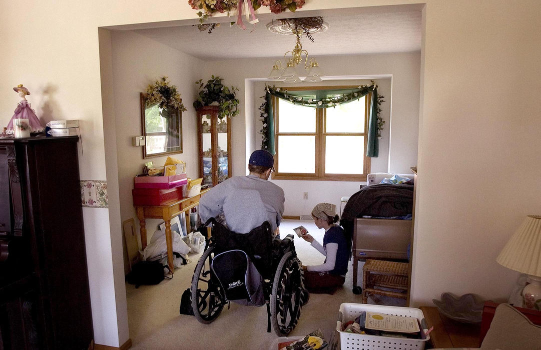 Third Place, Team Picture Story - Mike Levy / The Plain DealerRyan and Barb look at family photos after Ryan came home from the hospital.  When Ryan saw the ramp his friends had built outside, he scolded Barb.  "I'm not going to be in this wheelchair forever.