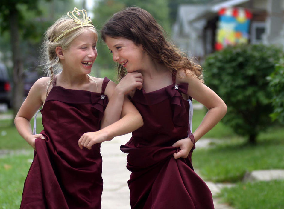 First Place, Enterprise Feature - Stephanie J. Smith / The Lima NewsCousins Bella Frye (left), and Gabrielle Poling play dress-up as they walk down the sidewalk outside their aunt's home on Pierce Street in Lima. The girls said they found the matching gowns in a store and that they were originally from a wedding.