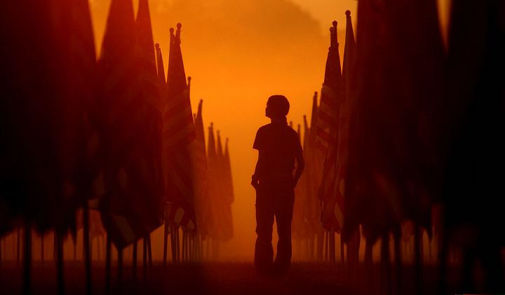 Award of Excellence, Enterprise Feature - Ken Love / Akron Beacon JournalFranki Lichtenberger, 14, of Akron stands among some of the 2,500 flags at sunrise at Goodyear Metro Park that is part of the Patriot's Healing Field Flag Memorial on September 8, 2006 in Akron.  