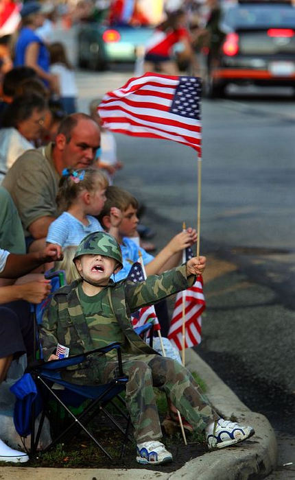 Award of Excellence, Enterprise Feature - Scott Shaw / The Plain DealerWilliam Hinton, 5, yells for "Candy!" as he  waves a flag during the Fourth of July parade in Berea. He was sporting a hole as he just lost his first tooth the other day. 