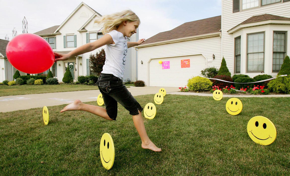 First Place, Feature Picture Story - John Kuntz / The Plain DealerBailey leaps over the smiley faces that were placed as decorations in the front yard of the Bihn home in Olmsted Falls August 22, 2006 in preparation of the return home of her sister Dakota after spending almost 7 months in Durham, NC battling her Tay-Sachs disease. 