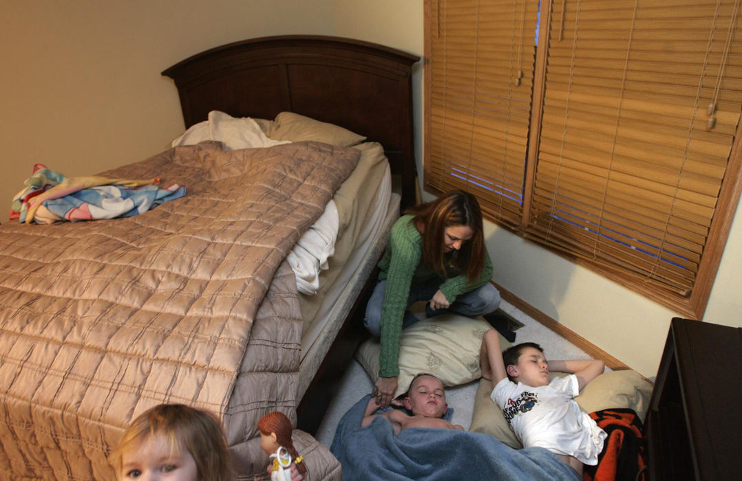Third Place, Feature Picture Story - Chris Russell / The Columbus DispatchIn their roomier new home, Lee Ann Ivy wakes up her sons Harrison and Caleb (left to right) who sneak from their separate bedrooms into her room  at night to sleep together and be closer to her.  