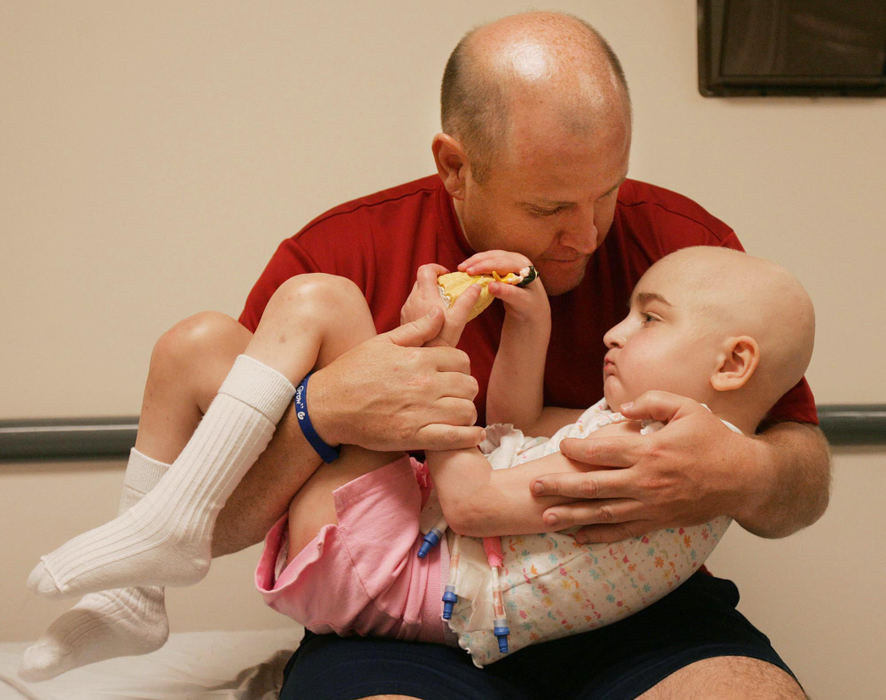 First Place, Feature Picture Story - John Kuntz / The Plain DealerKen holds his daughter Dakota May 29, 2006 during a check up at Duke Medical Center in Durham, NC.   Dakota was diagnosed with juvenile onset Tay-Sachs disease and the progression of the brain debilitating disease has affected her speech and motor skills.    