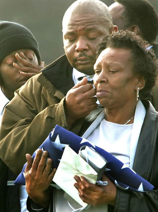Second Place, General News - Chuck Crow / The Plain DealerLooking down at the casket of her husband is Bobbie Payne, as her son Victor, wipes a tear from her cheek. Bobbie Payne was just presented with the flag from her husbands casket. Norman Payne's remains were found in a Laotian jungle, 38 years after he was listed as MIA during the Vietnam war. A funeral service was held at the Boyd & Son Funeral Home followed by a burial service with full military honors.