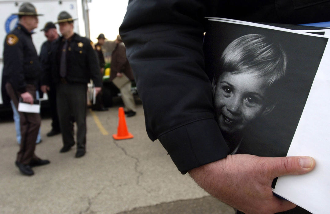 Second Place, News Picture Story - Marsahll Gorby / Springfield News-SunA Clark County Sheriff's deputy holds copies of two and a half year old Cayden Workman's picture to hand out to search and rescue personnel at the staging area in the Greenon High School parking lot.