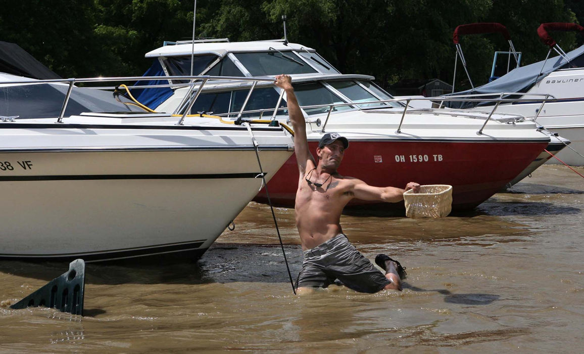 Third Place, News Picture Story - Thomas Ondrey / The Plain DealerThe floodwaters of the Grand River hit the yacht clubs clustered near its mouth in Fairport Harbor particularly hard, washing dozens of boats out into Lake Erie. Despite a dangerous current from the floods, Todd Van Allen of Concord removed personal items from his boat,  still moored at Riverbend Marina, although the dock itself had torn loose and moved several yards downstream from its normal location.