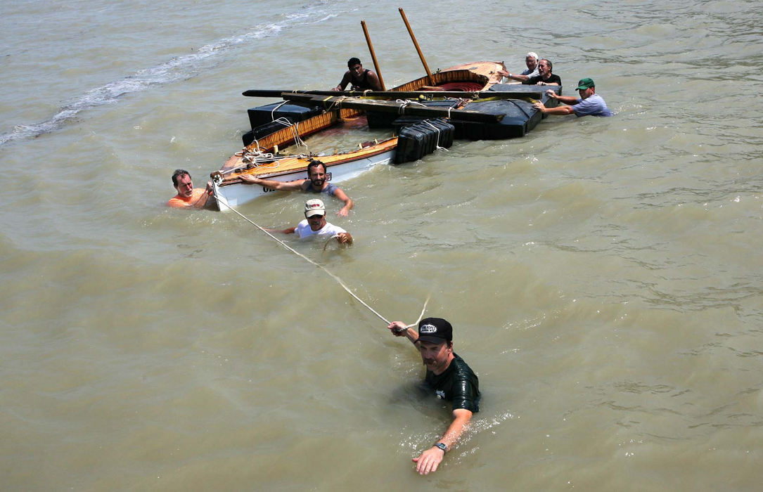Third Place, News Picture Story - Thomas Ondrey / The Plain DealerA crew of volunteers pulls to safety the shattered wreck of the Moonfleet, an historic replica steam tender normally moored on the Grand River, but washed by the storm out into Lake Erie. The volunteers, led by Tom Jackson, front, found the boat two miles east of the river's mouth on a Lake Erie beach and walked its hull back to its dock.