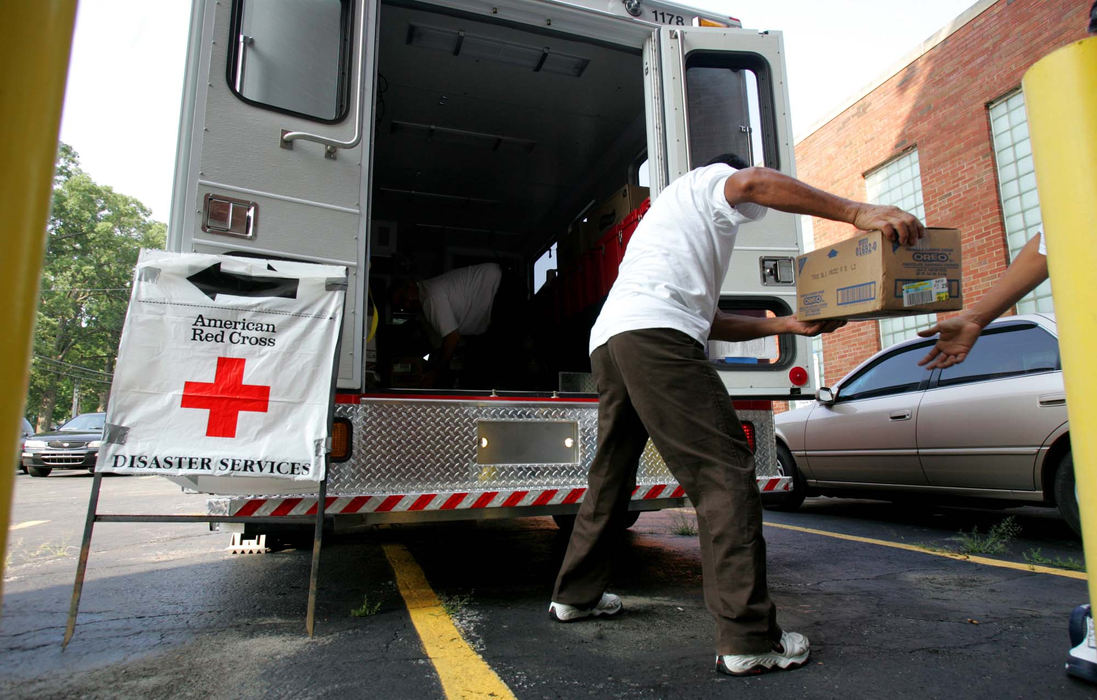 Third Place, News Picture Story - Thomas Ondrey / The Plain DealerRogelio Porrorsoto hands off more emergency water from a Red Cross supply truck backed up to the emergency shelter set up at Painesville Harvey High School to care for people made homeless by the flooding. Floodwaters overwhelmed the municipal water plant, making bottled water particularly valuable to flood victims.