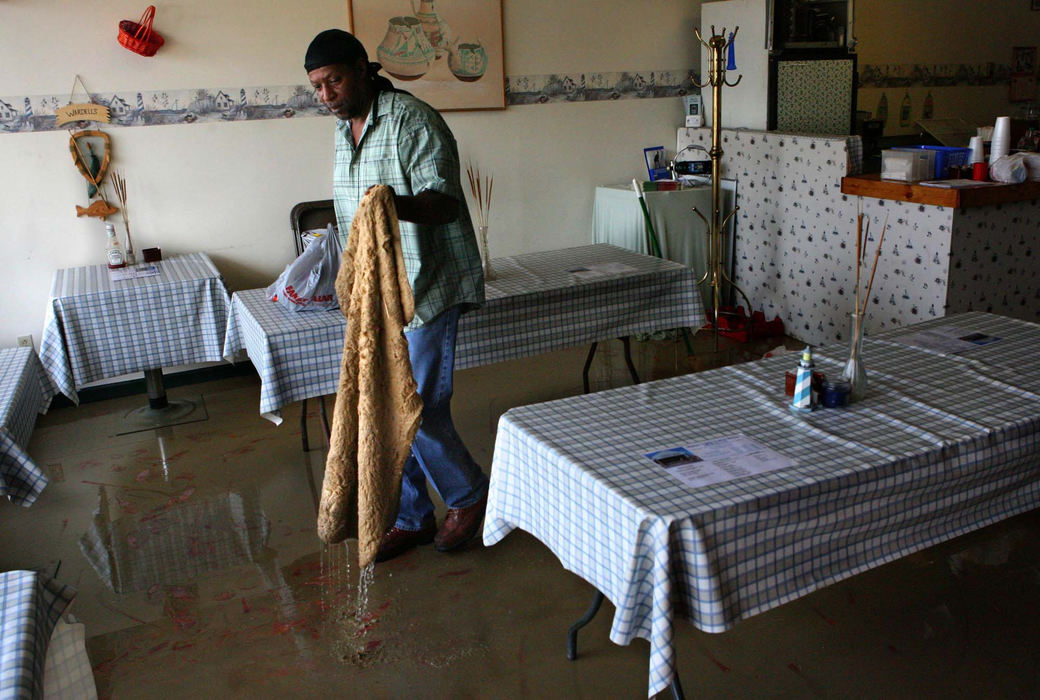 Third Place, News Picture Story - Thomas Ondrey / The Plain DealerWayne Ferguson of Painesville cleans up the muddy mess left behind by floodwaters in Harbor Lights Coffee House and Restaurant in Fairport Harbor.