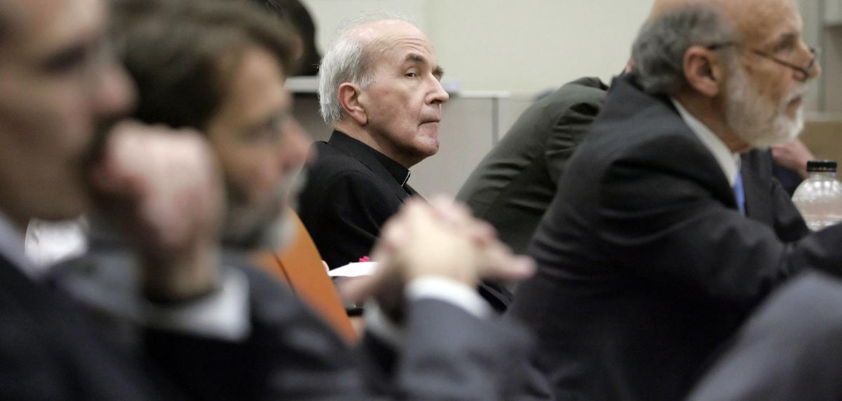 First Place, News Picture Story - Andy Morrison / The BladeThe Rev. Gerald Robinson watches a witness take the stand during his murder trial, May 4, 2006. Robinson is on trial for the 1980 murder of Sister Margaret Ann Pahl. At left are Lucas County assistant prosecuting attorneys Larry Kiroff and Dean Mandros. At right is defense attorney Alan Konop.