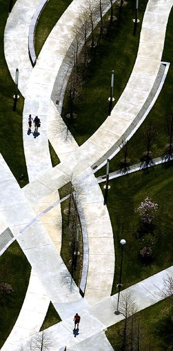 Award of Excellence, Pictorial - Glenn Hartong / Cincinnati Enquirer A trio of pedestrians cast dark shadows as they walk along the serpentine sidewalks on Campus Green on the University of Cincinnati on a warm and sunny afternoon. This photo was shot from a helicopter at 1200 feet above Martin Luther King Drive.