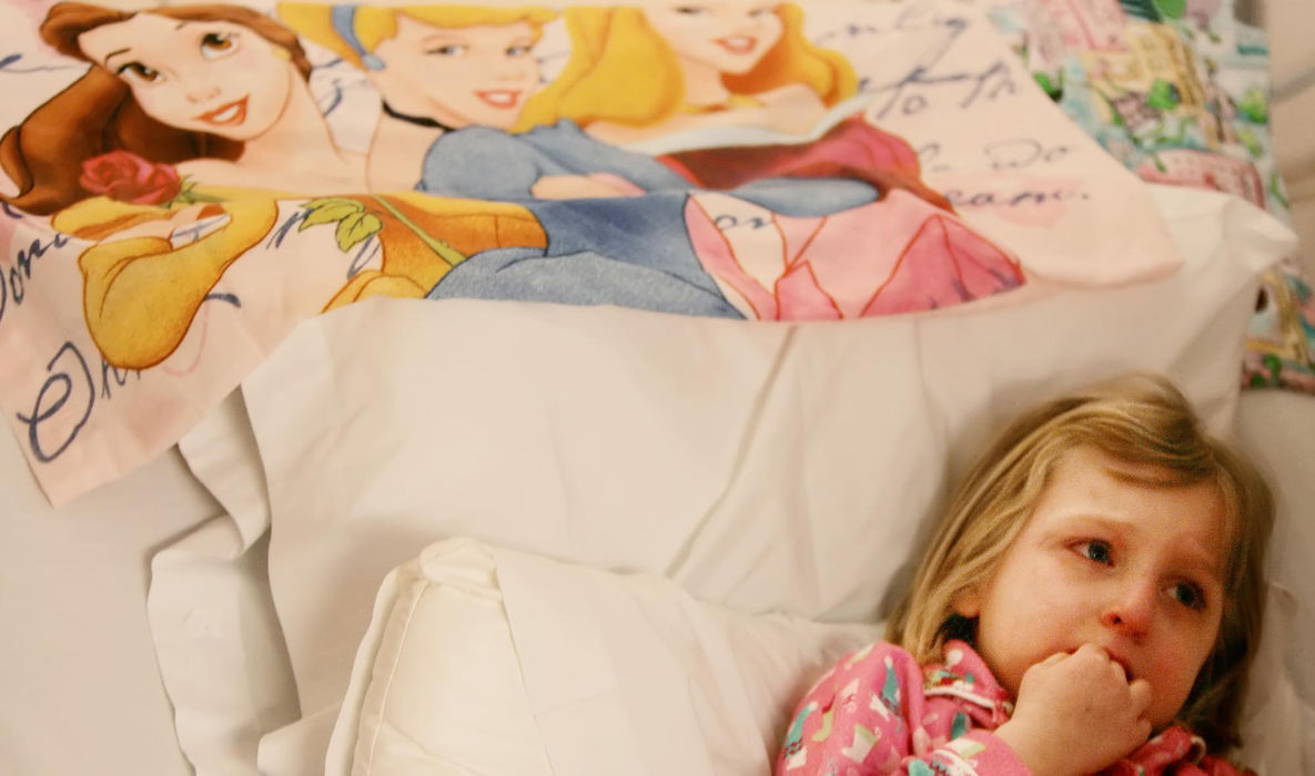 First Place, Photographer of the Year - John Kuntz / The Plain DealerDakota Bihn, 6, of Olmsted Falls looks at her mother Julie with apprehensive eyes from her hospital bed at Duke Medical Center in Durham, North Carolina with her own pillow donning some of the Disney Stdio beauties January 27, 2006.  Dakota was diagnosed with infantile Tay Sachs disease, a brain debilitating disease that has no cure and results in paralysis and eventually death, and is at Duke Medical Center to undergo a controversial cord blood transplant to replace her blood with donor stem cells.  