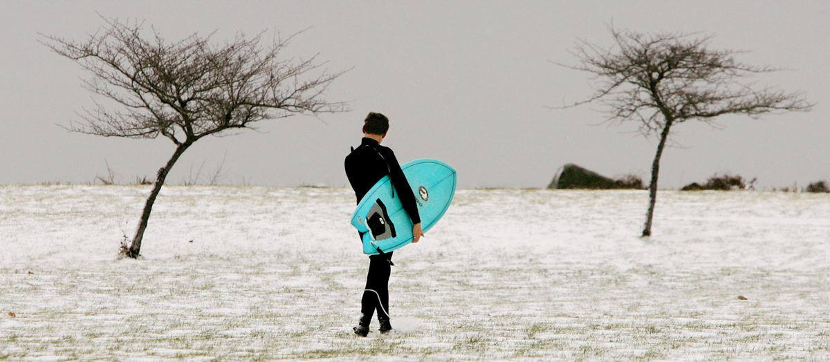 First Place, Photographer of the Year - John Kuntz / The Plain DealerBen Haehn of Cleveland walks back to his vehicle with surf board in tow to get a cup of hot chocolate during a break of surfing Lake Erie January 18, 2006 at Edgewater Park.  Ben said the dive suit keeps him warm enough in the upper 20's temperature and he jumps at any opportunity to run out and surf in the Winter when weather conditions are good-for surfing that is.