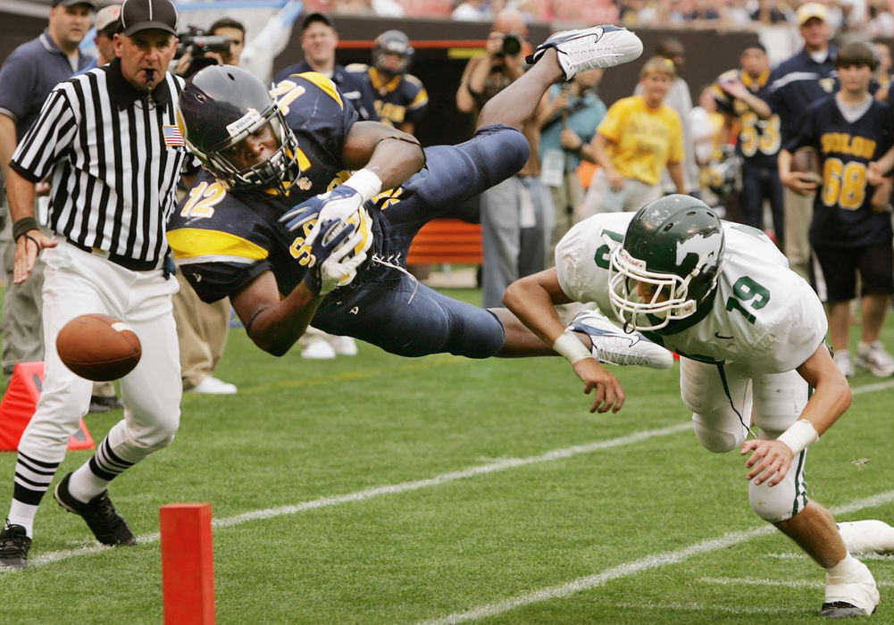 First Place, Photographer of the Year - John Kuntz / The Plain DealerSolons' Deloreen Martin (left) loses the ball on a hit by Strongsvilles' Chris Svancara in the second quarter August 26, 2006 in the 2006 Charity Game played at the Cleveland Browns Stadium.  The ball fell out of bounds and Solon retained possession two yards shy of the end zone and settled for a field goal.    