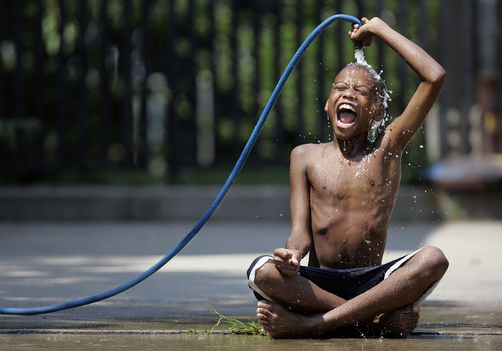 Second Place, Photographer of the Year - Chris Russell / The Columbus DispatchDespite a brutal heat wave, the city of Columbus decided to cancel its previous policy of opening up fire hydrants for heat relief so Marshawn Brown, 11, sat in his driveway with a garden hose and cooled off.  