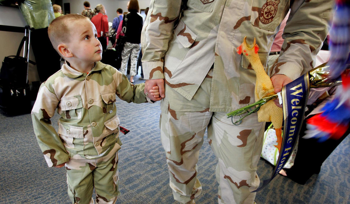 Second Place, Photographer of the Year - Chris Russell / The Columbus DispatchZachary Roach holds hands with his dad, Master Sgt. Matthew Roach, as he arrives back home, carrying a rubber chicken, after serving in Iraq.  Roach works as a firefighter at Rickenbacker Air National Guard Base and as a clown on the weekends.