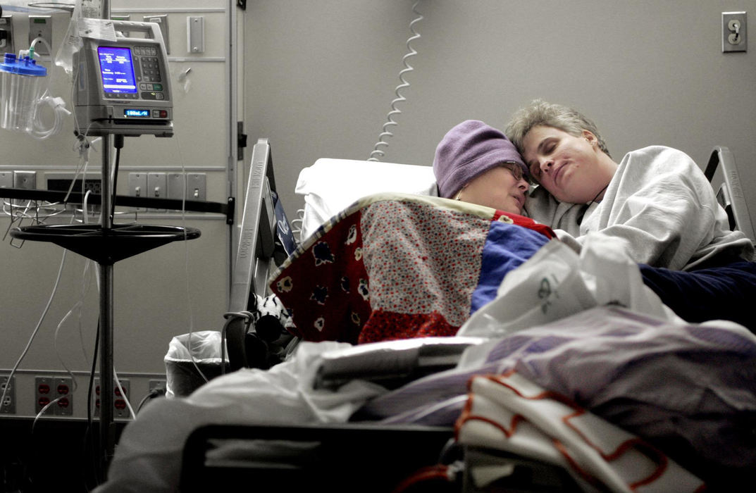 Second Place, Photographer of the Year - Chris Russell / The Columbus DispatchLee climbs into bed with Audrey at the Arthur James Cancer Center.  Audrey was running a high temperature and wore the hat constantly to try and keep her bald head warm .  