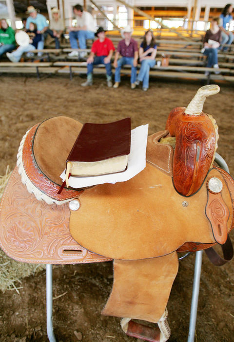 First Place, Photographer of the Year - John Kuntz / The Plain DealerPastor Royce Gregory of the Life Brand Cowboy Church uses his daughters saddle for a pulpit before delivering his sermon in the indoor riding arena at the Twin Pines Stable for those seated in the grandstand and riders aboard thier horses in Newbury July 13, 2006.  