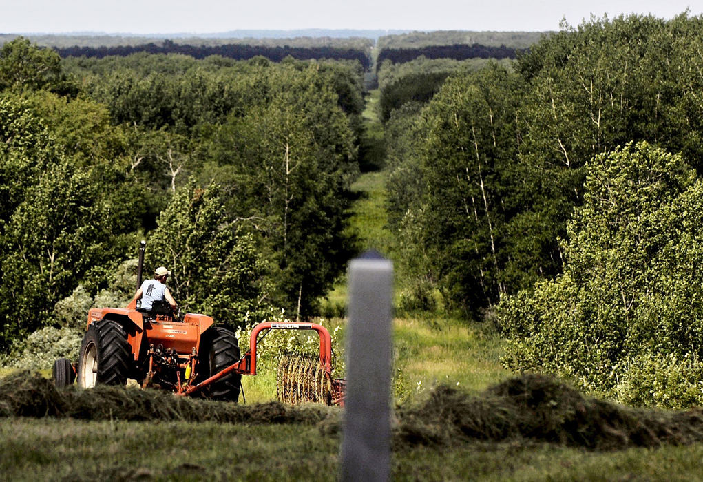 Third Place, Photographer of the Year - Greg Ruffing / FreelanceA farmer toiling the farmland adjacent to the U.S.-Canada border near Dunseith, North Dakota. In the foreground is the official boundary marker, one of thousands located along the border. In the background can be seen a cut through the trees, called a boundary vista, approximately 20 feet wide, maintained by the International Boundary Commission.