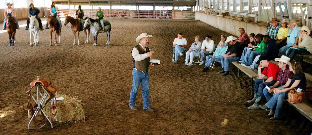 First Place, Photographer of the Year - John Kuntz / The Plain DealerRoyce Gregory delivers a sermon in the indoor riding arena at the Twin Pines Stable for those seated in the grandstand and riders aboard their horses in Newbury, July 13, 2006.  Royce started his ministry May 2 called the Life Brand Cowboy Church geared to folks around the stables who could not attend a Sunday worship service or don't like the conventional church setting.   