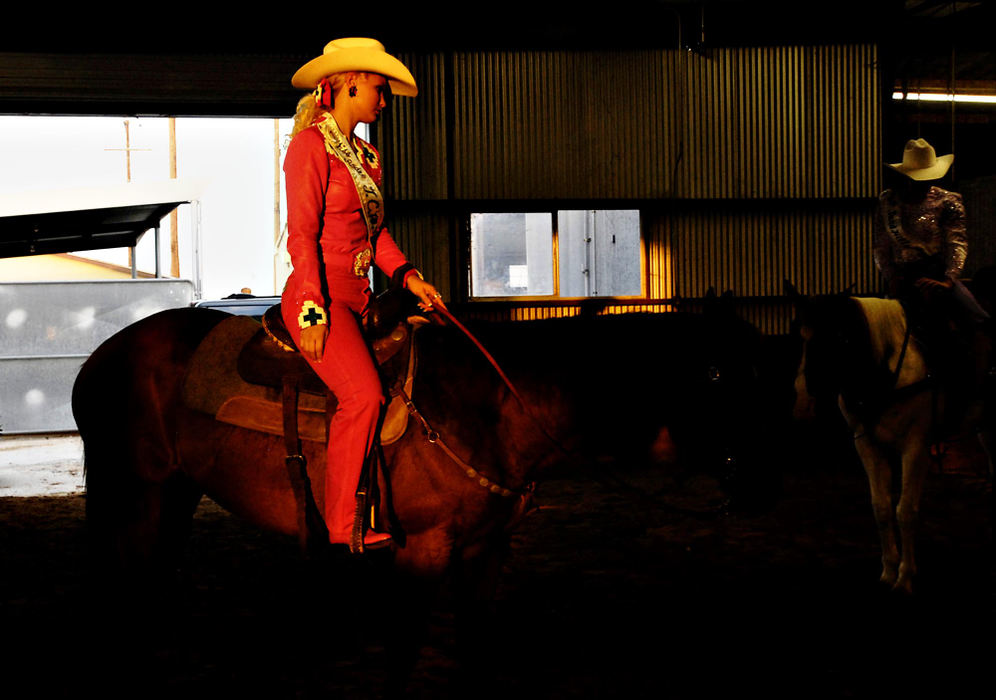 Third Place, Photographer of the Year - Greg Ruffing / FreelanceA shaft of sunlight illuminates Miss Tyler County Western Weekend Sweetheart, Kira Knaupp (left) of Fredericksburg, Texas, as she waits with her horse before competing in the horsemanship category. The horsemanship skill test includes tasks such as controlling the horse, riding at different speeds, and mounting and dismounting.