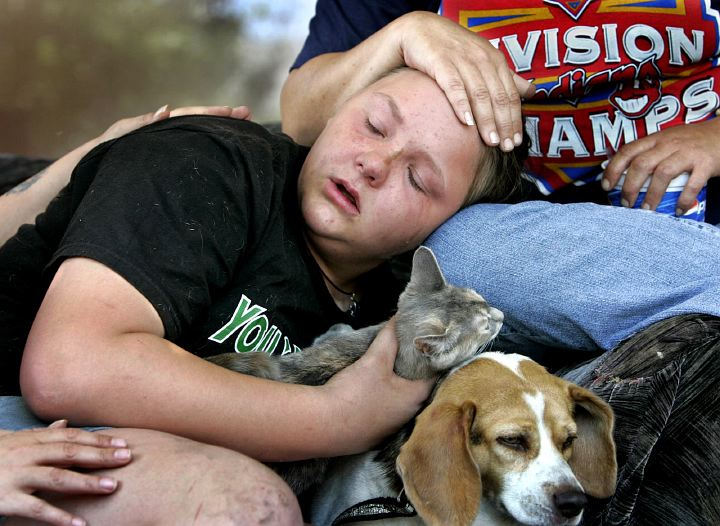 Award of Excellence, Spot News over 100,000 - David I. Andersen / The Plain DealerMaggie Skobel, 13, hangs onto her cat, Trouble and dog, Goldie as she is comforted on a porch across the street from her house at 2025 W. 98th Street in Cleveland which caught fire forcing herself, her grandmother and two cousins to flee.  The fire gutted the porch and front living room. No injuries reported.