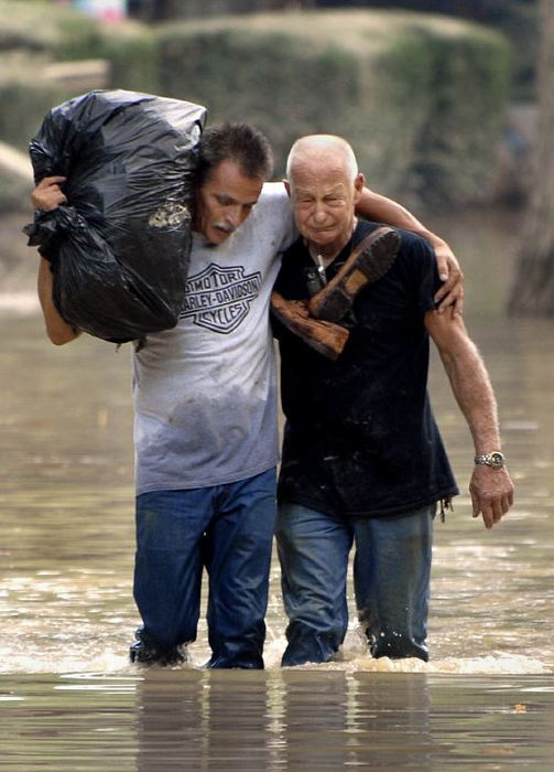 First Place, Spot News under 100,000 - Michael Blair / The News-HeraldRick Tomlins (left) consoles his dad  Don Holt as the pair carry belongings from inside of the flooded Millstone condominiums in Painesville.