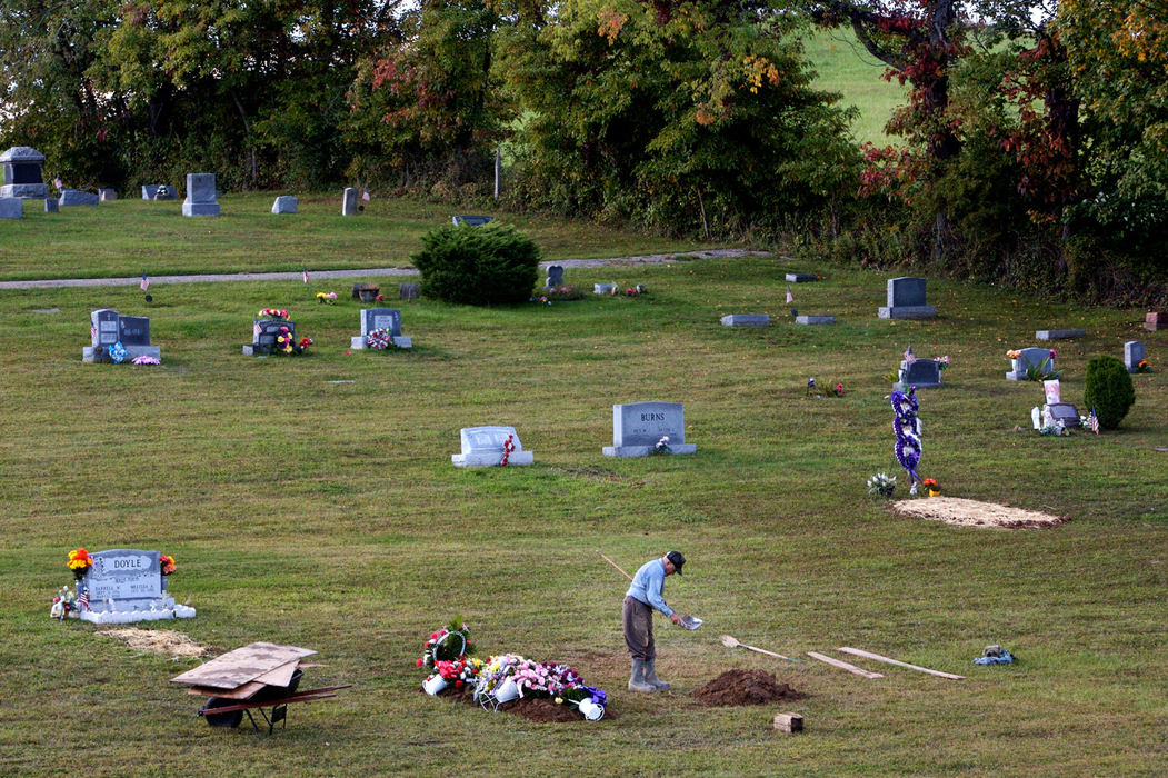 Second Place, Student Photographer of the Year - Michael P. King / Ohio UniversityIntroduction: Dorsel Bibbee of Coolville, Ohio, is digging for life. At the age of 72, Bibbee is one of the few remaining gravediggers in Southeast Ohio who still dig by hand. He began when he was 19. He suffers from arthritis and now has difficulty climbing in and out of the graves he digs. Most funeral directors now only hire men with mechanical digging equipment. Bibbee finishes a burial at Coolville Cemetery, Sept. 29, 2006. Bibbee serves more than 20 Southeast Ohio cemeteries at $350 for each grave he digs.