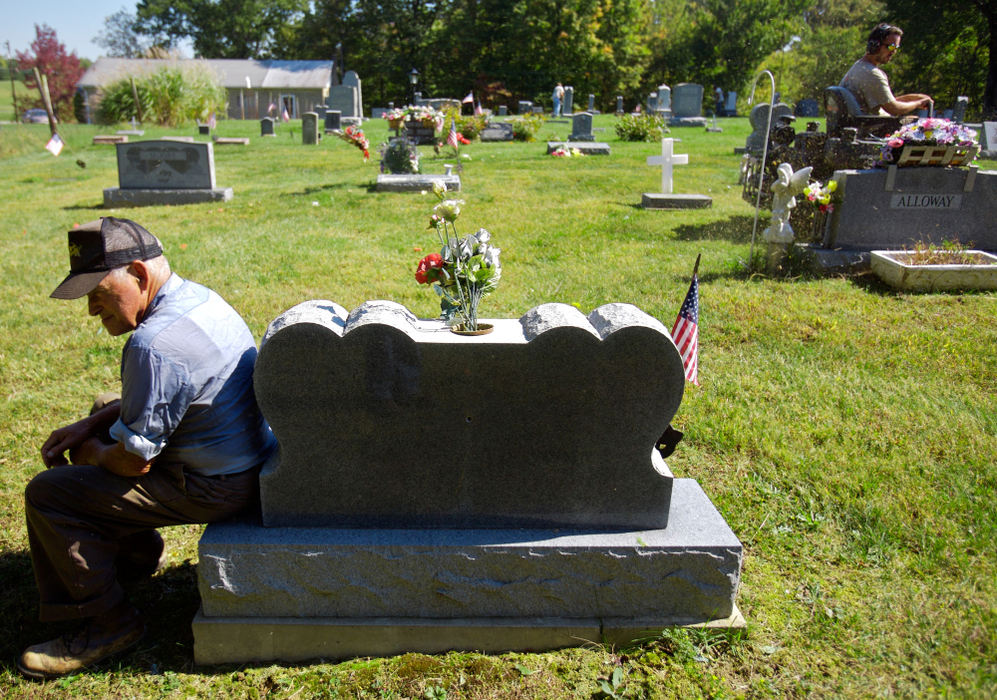 Second Place, Student Photographer of the Year - Michael P. King / Ohio UniversityBibbee rests on a gravestone while a township grounds crew mows at Fairview Cemetery, north of Coolville while digging on Oct. 3, 2006.