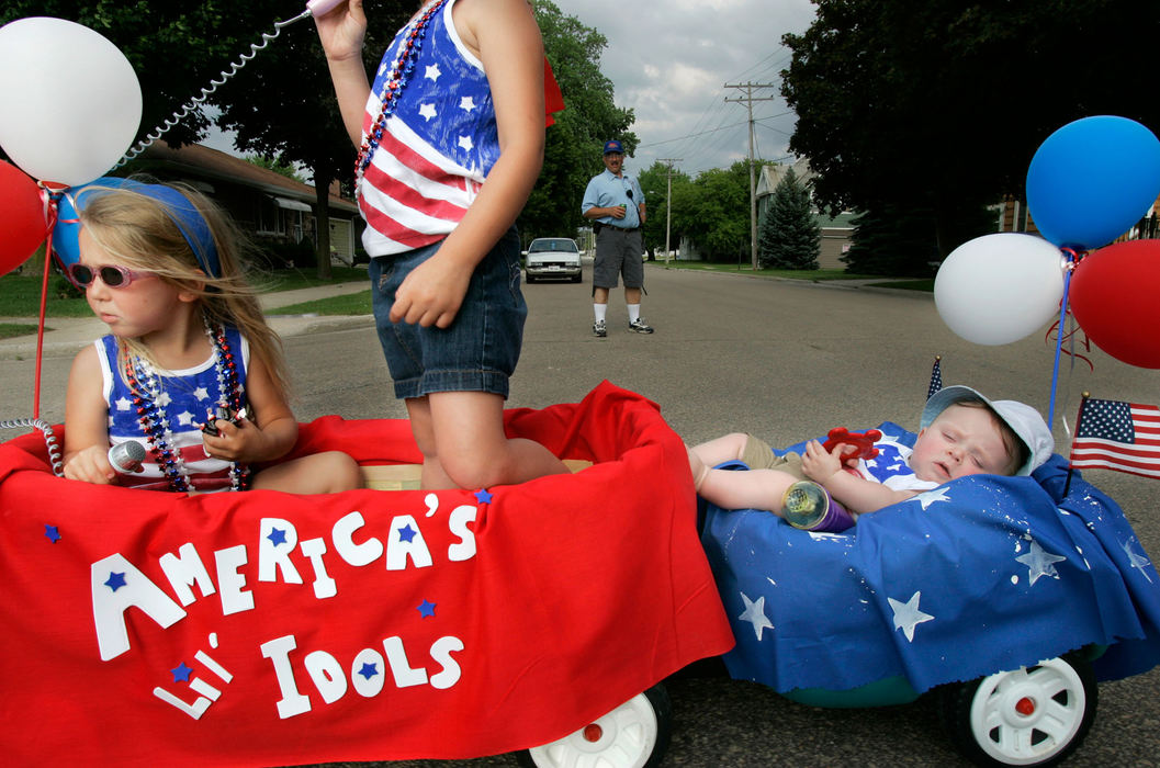 Second Place, Student Photographer of the Year - Michael P. King / Ohio UniversityEmily, 3, Allison, 5, and Trey Schneider, 6 months old, of Chilton, ride through the briefly barricaded streets of Hilbert, Wis., during the children's parade to kickoff Fourth of July celebrations on July 3, 2006.