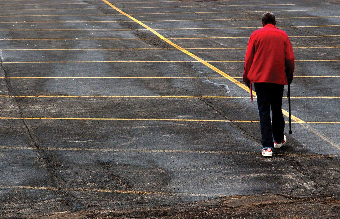First Place, Student Photographer of the Year - David Foster / Kent State UniversityGlen walks through an empty parking lot after an unsuccessful look for employment. He walks with a cane due to a hip problem. Doctors say he will be 60 years old before he could get the hip replacement he needs to be mobile. 