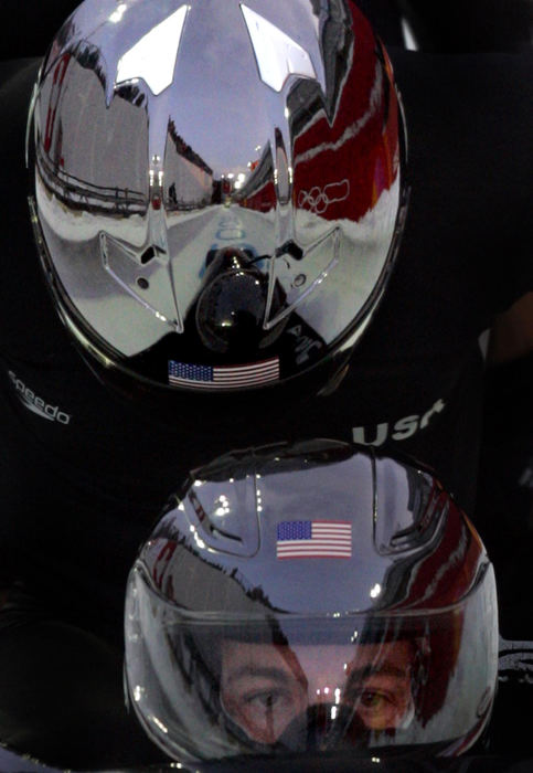 Second Place, Sports Picture Story - Joshua Gunter / The Plain DealerWith the track ahead of them reflected in the polished black helmets, America's sled USA-1, with Todd Hayes at the helm, tuck in for their first run in the men's four-man bobsled competition Saturday, February 25, 2006 in Cesana Pariol, Italy. The team finished seventh. 