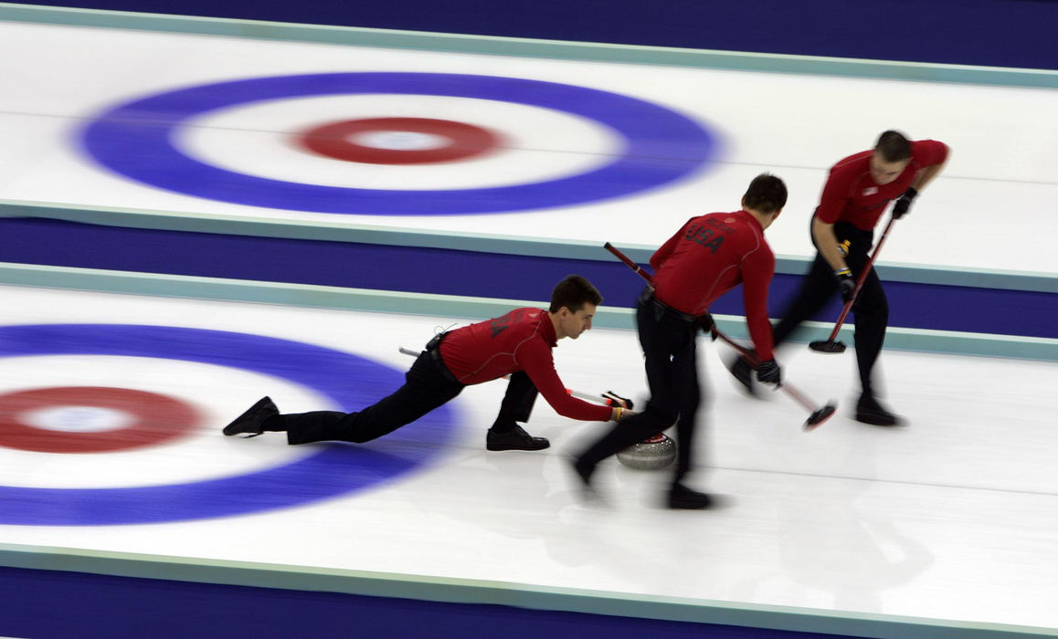 Second Place, Sports Picture Story - Joshua Gunter / The Plain DealerTeam skip Pete Fenson glides on the ice as he pushes the stone during the bronze medal curling match against Great Britain, February 24, 2006 in Pinerolo Palaghiaccio, Italy. America beat Great Britain for the bronze 8-6. 