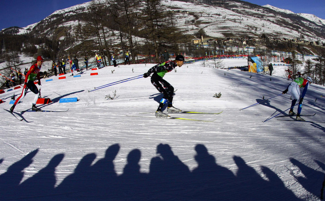 Second Place, Sports Picture Story - Joshua Gunter / The Plain DealerSkiers speed by the shadows of the crowd during the men's cross country team sprint semi finals, February 14, 2006 in Pragelato Plan, Italy. 