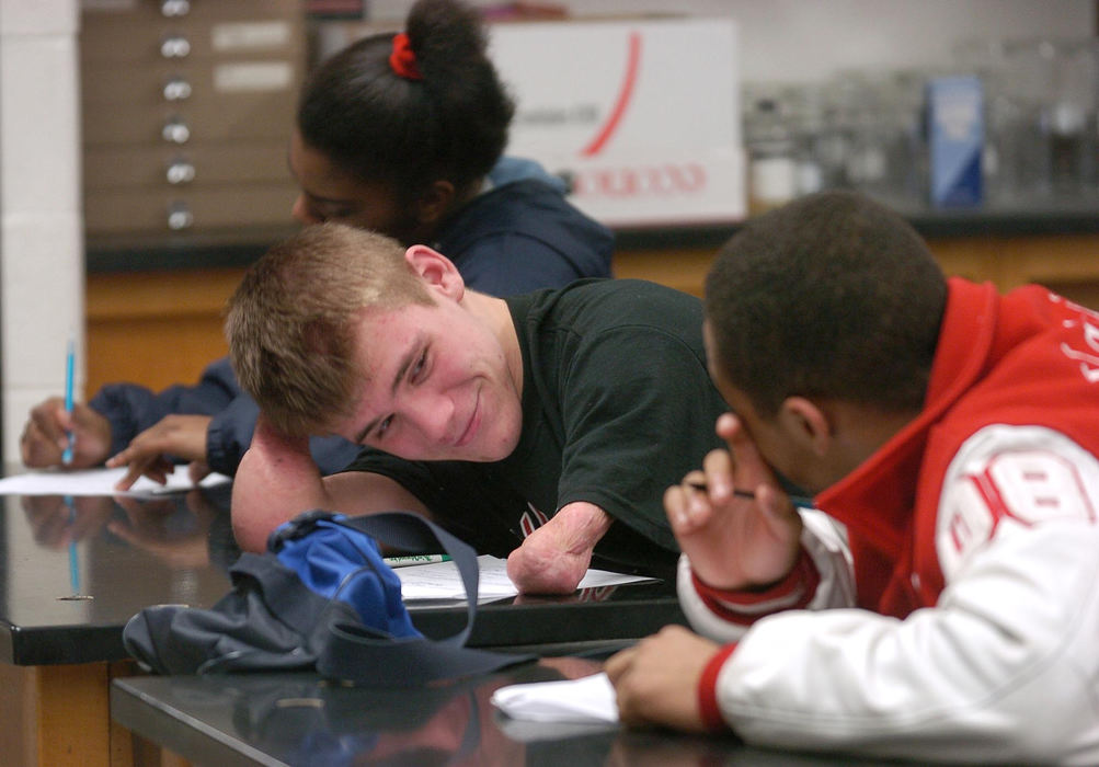 First Place, Sports Picture Story - Jeff Swinger / Cincinnati EnquirerDustin Carter was born with full arms and legs. When he was 5, a rare infection nearly killed him. His limbs were amputated to save his life. Today Dustin is a Hillsboro High School sophomore, and feared wrestling opponent. Dustin reacts to his buddy (right) Kendal Coleman during their Biology class.