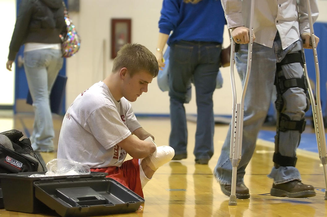 First Place, Sports Picture Story - Jeff Swinger / Cincinnati EnquirerWhere other wrestlers can just put their shoes on Dustin spends about twenty minutes taping his legs for protection.  