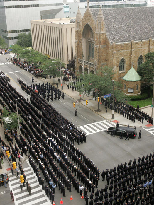 Second Place, Team Picture Story - xx / The Plain DealerPolice line the corner of E. 9th and Superior as the hearse carrying slain Cleveland police officer A.J. Schroeder arrives at St. John's Cathedral.