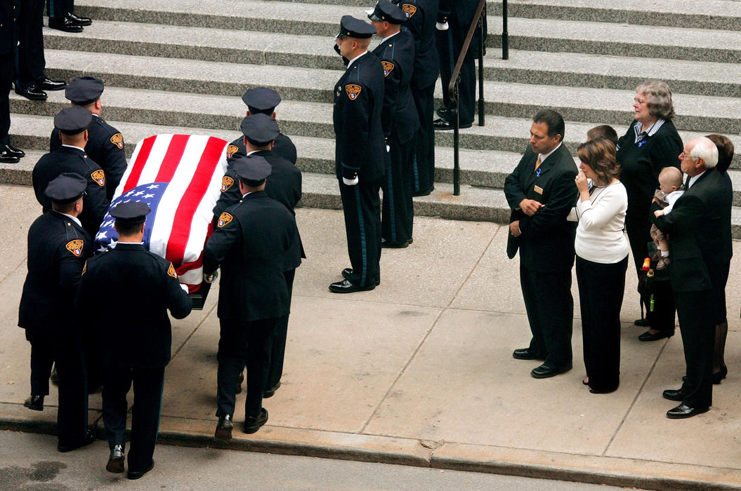 Second Place, Team Picture Story - JOHN KUNTZ / The Plain DealerAmy Schroeder, in white, watches as pallbearers carry the  casket with the body of her husband into St. John Cathedral.   