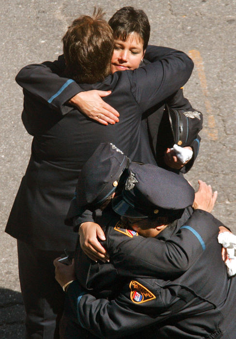Second Place, Team Picture Story - JOHN KUNTZ / The Plain DealerCleveland police officers console each other after the funeral Mass.    